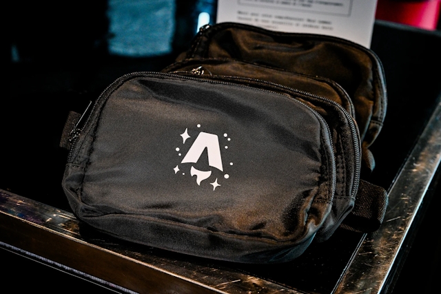 A black belt bag branded with the Astro Together logo in white.