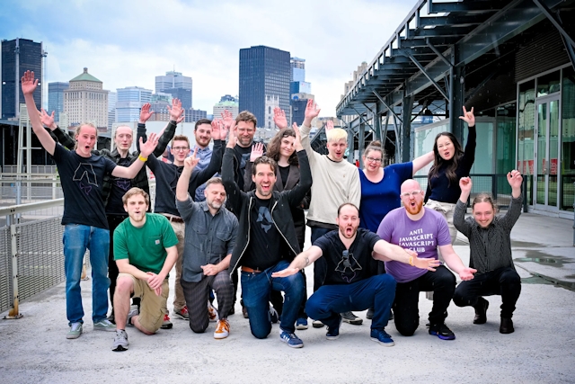 The Astro core team poses with their hands up outside the meetup venue with the Montreal skyline behind them.