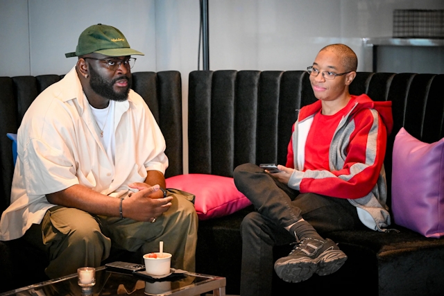 Darius, core contributor, listening intently to a guest while both are sitting in the lounge.