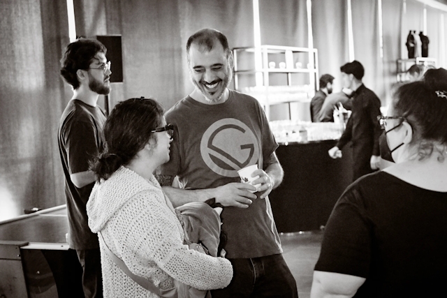 A black and white photo of representative from Gatsby laughing while listening to a guest speak.