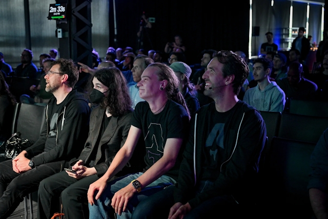 A shot of the front row, where onlookers are smiling and laughing while watching Ben Holmes on stage.