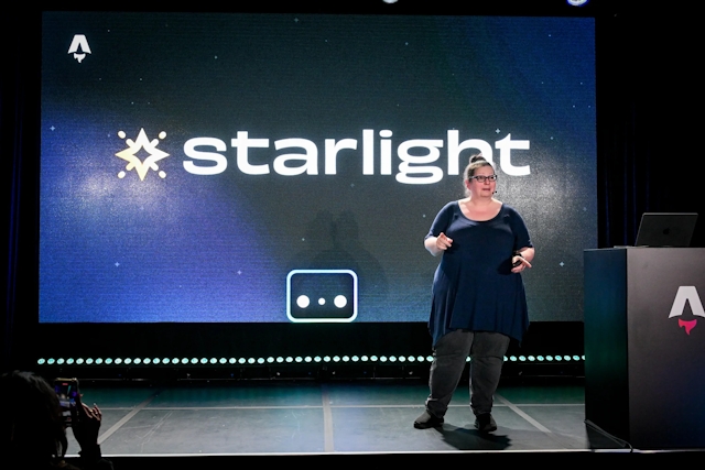 Sarah Rainsberger speaking on stage next to an Astro-branded podium. The Starlight logo is displayed alongside Houston behind her.