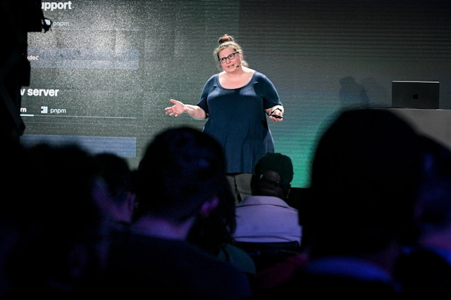 View from the audience of Sarah Rainsberger speaking on stage.