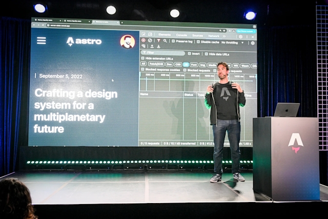Fred K. Schott speaking on stage next to an Astro-branded podium. He has a blog example open with the network window displayed.