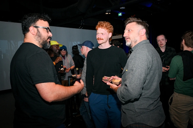 Guests chatting with one another holding their drinks.