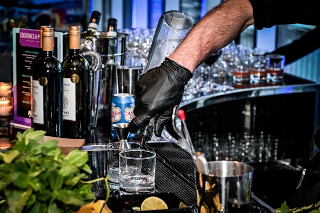 Closeup of a bartender pouring a drink.