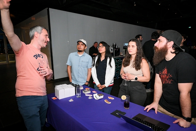 Sentry demos their product to a group of guest onlookers at their sponsor booth.