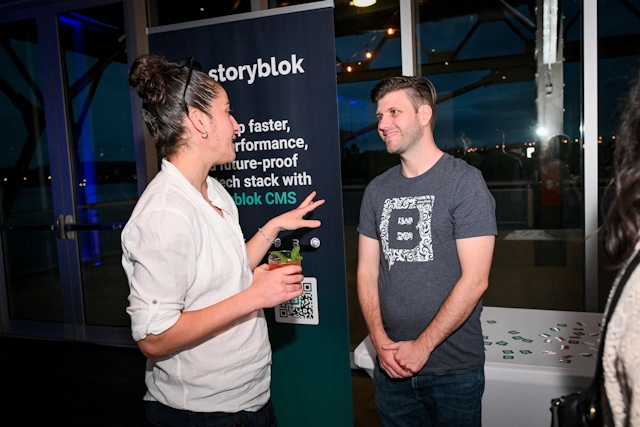 Storyblok explaining their product to a guest at their sponsor booth.